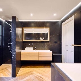 Modernes Badezimmer mit dunklen Marmorfliesen, Holzwaschtisch und begehbarer Dusche.